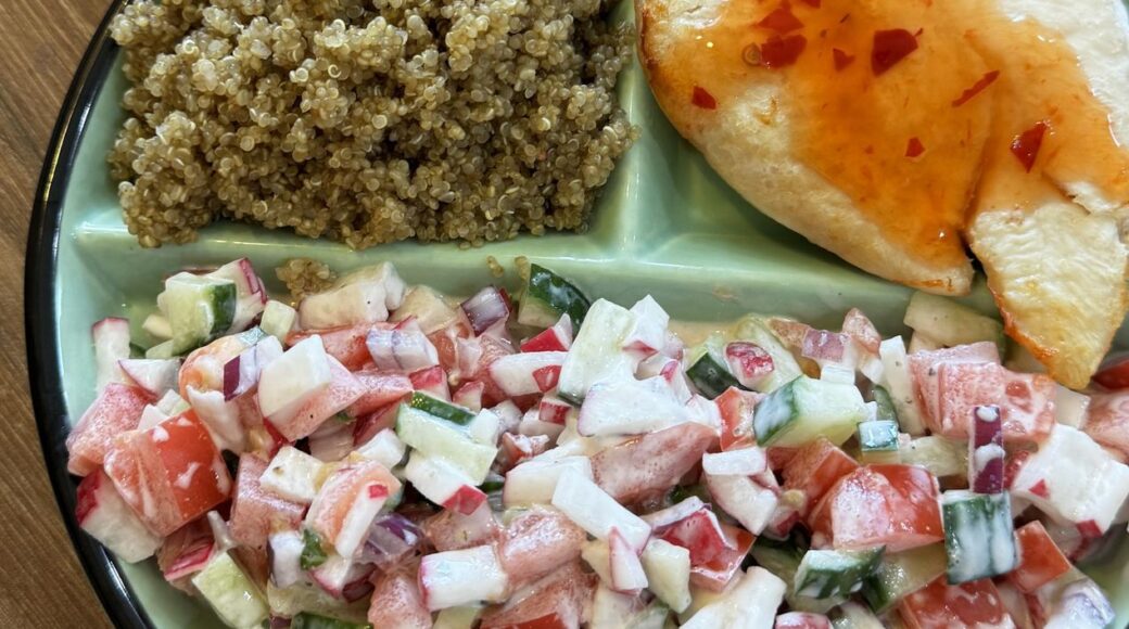 Quinoa, chicken with chilli sauce and fresh vegetable salad on a portion control plate
